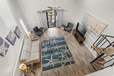 Living room featuring ceiling fan, light wood-type
