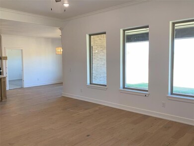 Spare room with ornamental molding, wood-type floo