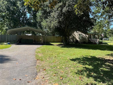View of yard with driveway and a carport