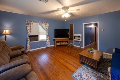 Living room with ceiling fan and wood-type floorin