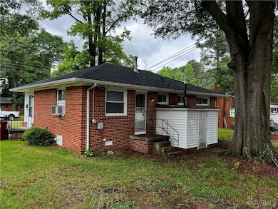 Back of house featuring brick siding, a lawn, and