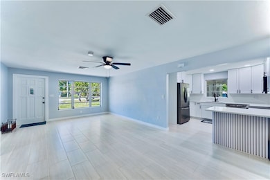 Unfurnished living room with a sink, a ceiling fan
