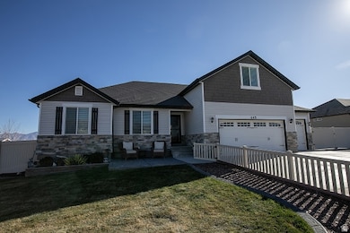 Craftsman house featuring stone siding, driveway, a patio, and an attached garage