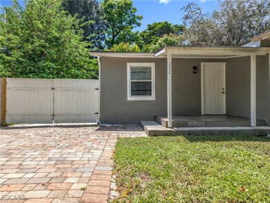 View of front facade with a gate, stucco siding, a front yard, and a patio