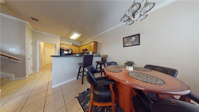 Dining area featuring crown molding, light tile pa