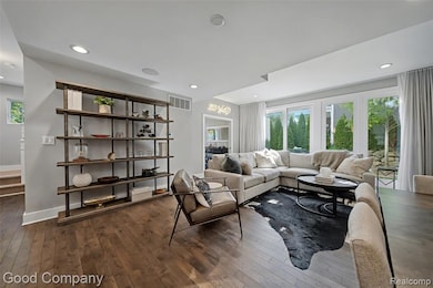 Living area featuring dark wood-style flooring and recessed lighting