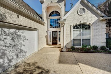 View of exterior entry with brick siding, driveway