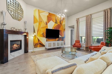 Living room with a tile fireplace, wood finished floors, recessed lighting, and a chandelier