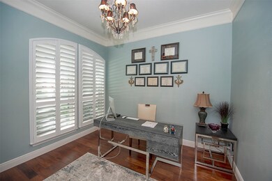 The study is designed as a calm workspace with its serene color palette, warm wood floors, gently arched windows and a touch of elegance with the chandelier.