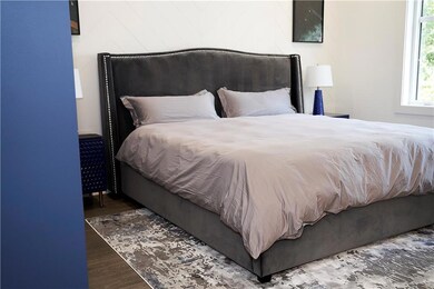 Bedroom with dark hardwood / wood-style floors