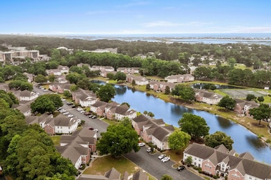 Aerial perspective of suburban area featuring a large body of water and a tree filled landscape