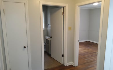 Hallway with dark hardwood / wood-style flooring