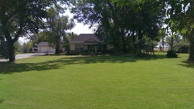 View of green lawn with driveway and an attached garage