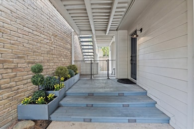 The inviting entryway showcasing these beautiful planter boxes is located on the side of the home. Access to the fully fenced backyard is through the wrought iron gate ahead.