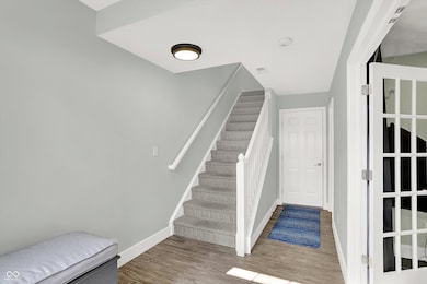 stairway with baseboards and wood finished floors