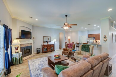 Living room with ceiling fan, ornamental molding, 