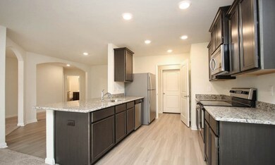 The kitchen is equipped with granite counter tops, expresso stained wood cabinets, and all new Whirlpool appliances.