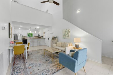Living room featuring baseboards, a ceiling fan, a