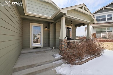 Snow covered property entrance with covered porch