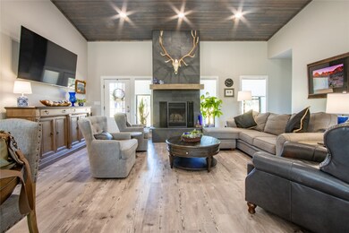 Living area with light wood-style flooring, wooden ceiling, and a fireplace