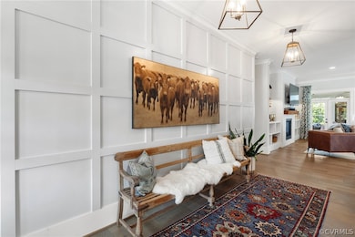 Corridor featuring ornamental molding, an inviting chandelier, and hardwood / wood-style floors