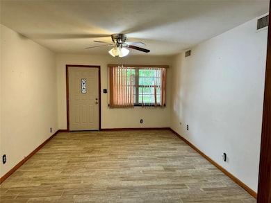 Foyer entrance with ceiling fan and light wood-style flooring