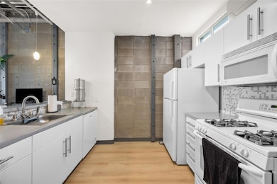 Kitchen featuring a sink, white appliances, light