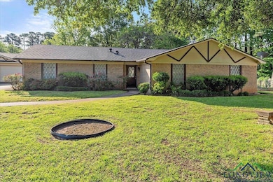 Ranch-style home with a shingled roof, a front law