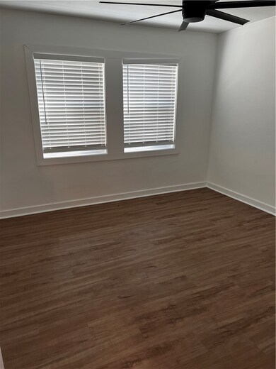 Spare room with dark wood-style floors, baseboards