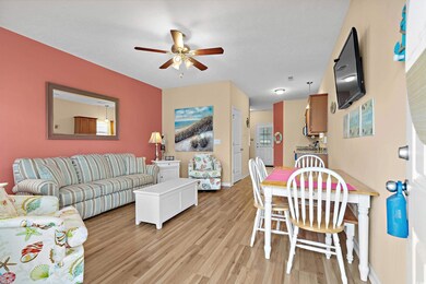 Living room with ceiling fan and light wood-type f