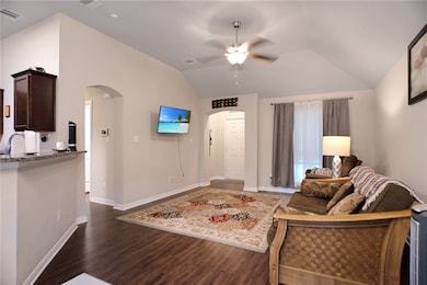 Living room featuring vaulted ceiling, a ceiling f