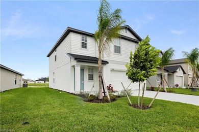 Traditional home with an attached garage, concrete driveway, and a front lawn
