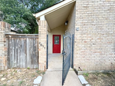 Property entrance with brick siding and a gate
