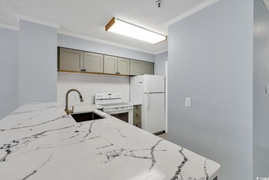 Kitchen with white appliances, gray cabinets, a textured ceiling, light stone counters, and crown molding