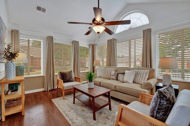 Living room featuring dark wood-type flooring, lofted ceiling, and plenty of natural light