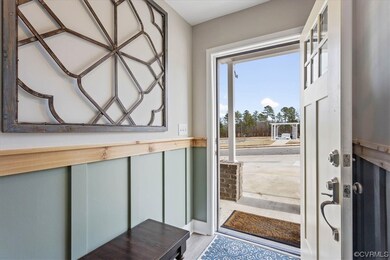 The bright foyer boasts custom board and batten wa