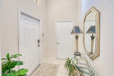 Foyer entrance featuring light tile patterned floors and a textured wall
