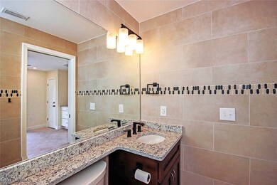 Bathroom featuring toilet, vanity, and tile walls
