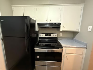 Kitchen featuring white cabinetry, light counterto