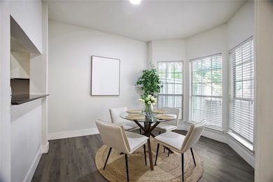 Dining area featuring dark wood-style floors and baseboards
