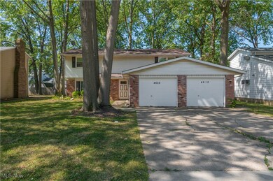 View of front of home featuring brick siding, concrete driveway, a front yard, and a garage
