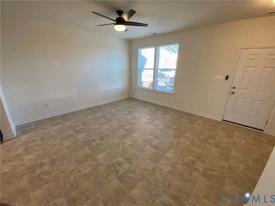 Foyer with baseboards and a ceiling fan