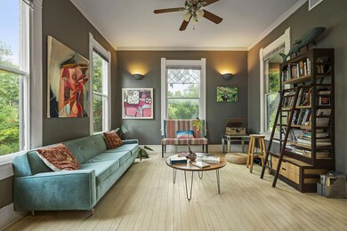 Sitting room featuring ornamental molding, wood-type flooring, and a ceiling fan