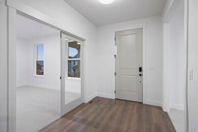 Foyer featuring dark wood-style flooring and baseboards