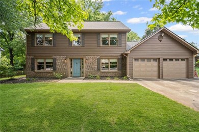 View of front of home with an attached garage, brick siding, concrete driveway, and a front yard