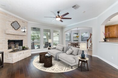 Living room with view to the backyard oasis, and large stone fireplace. Opens to kitchen and breakfast area.