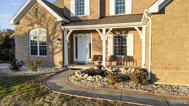 Doorway to property with a porch, a shingled roof, and brick siding
