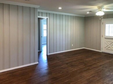 Living Room with wood floors,ornamental molding, and ceiling fan