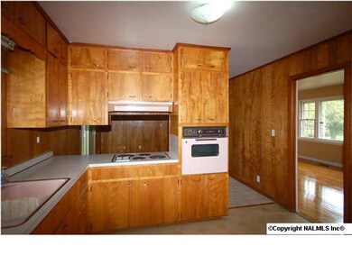 Kitchen features generous storage and window looking into back yard over sink. Opening to den from kitchen.