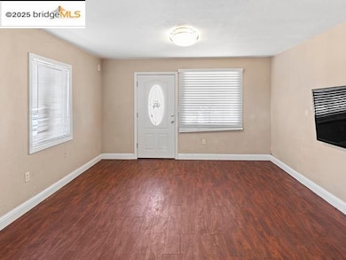 Entrance foyer featuring baseboards and dark wood-type flooring